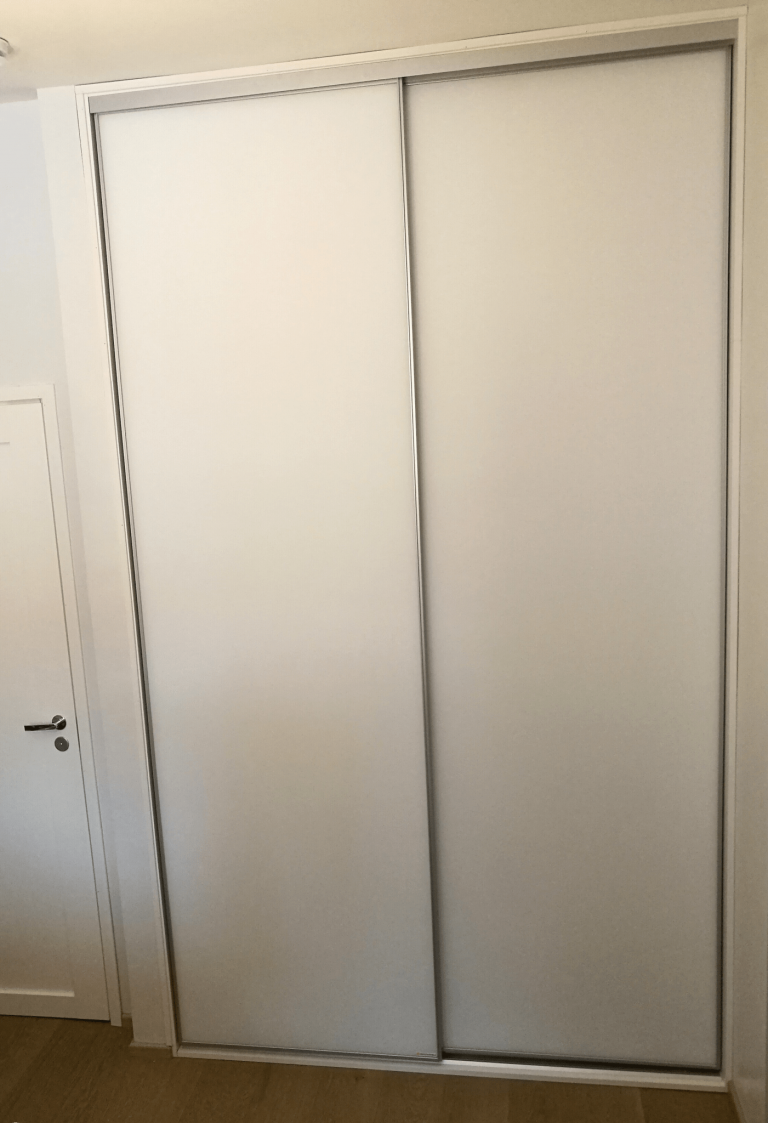 Valkoinen liukuovikaapisto mattavalkoisilla ovilla