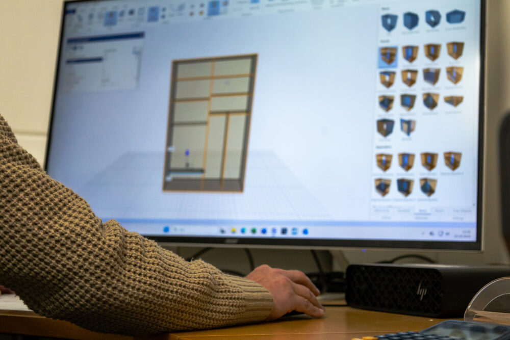 Suunnittelija tekee liukuovikaapin 3d-mallia tietokoneella vastuullista ja materiaalitehokasta tuotantoa varten.